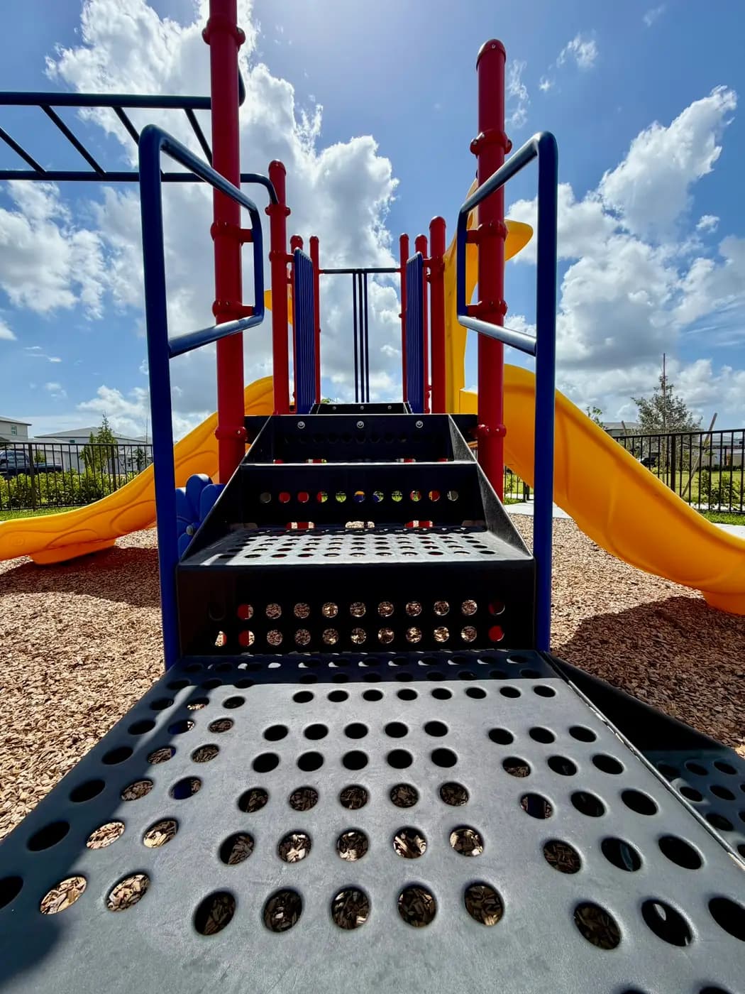 Steps and climbing deck between twin yellow slides at Acacia Groves