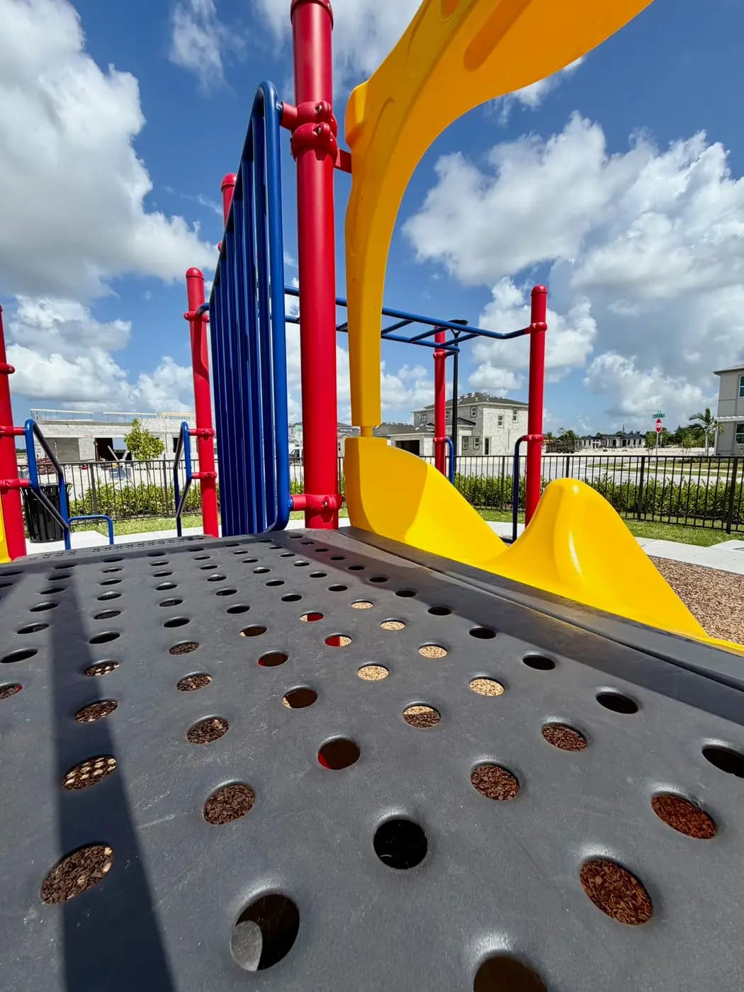 Yellow slides and overhead climbing bars on the Acacia Groves play system