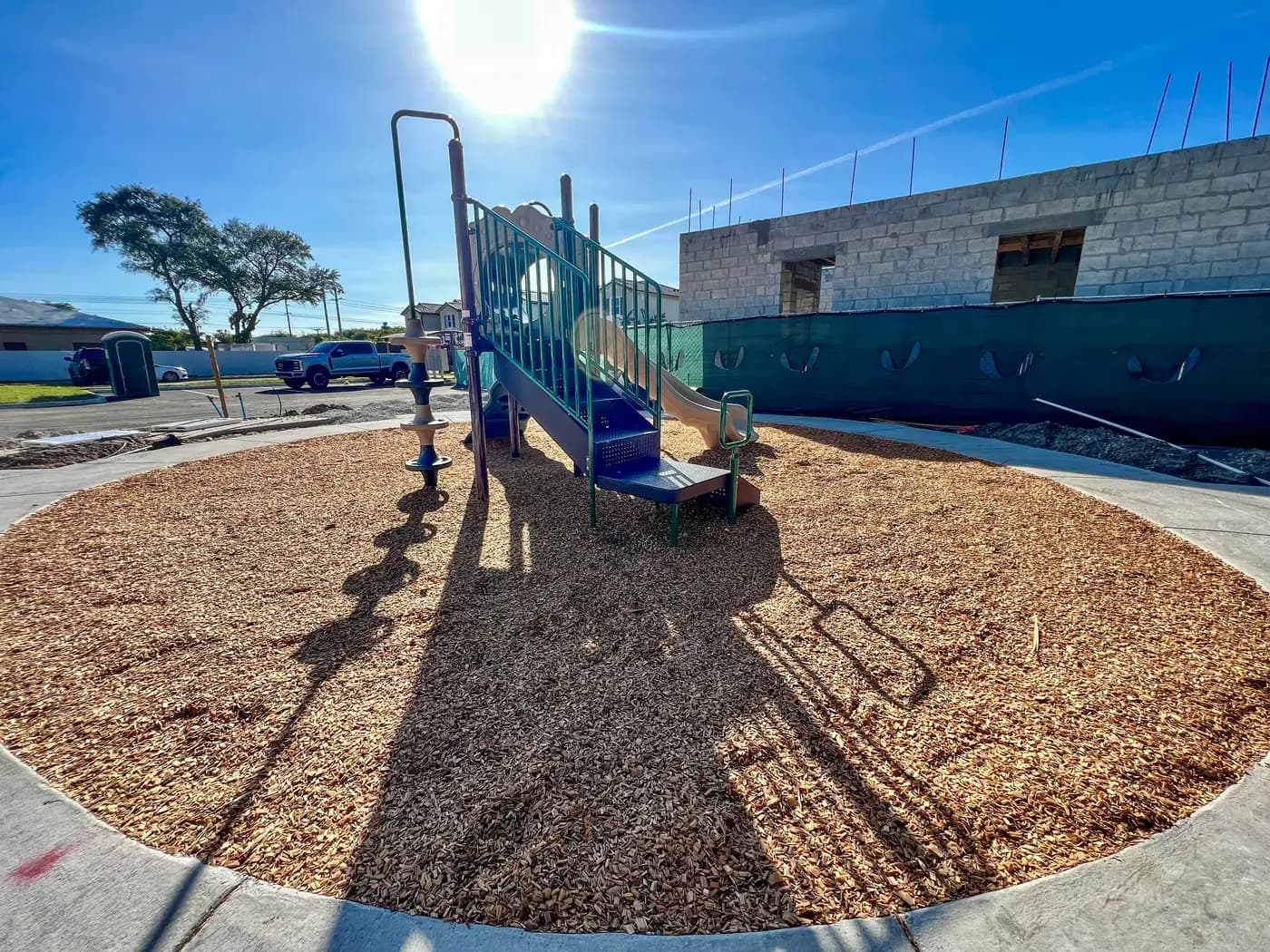 Azalea playground on engineered wood fiber behind a green fence