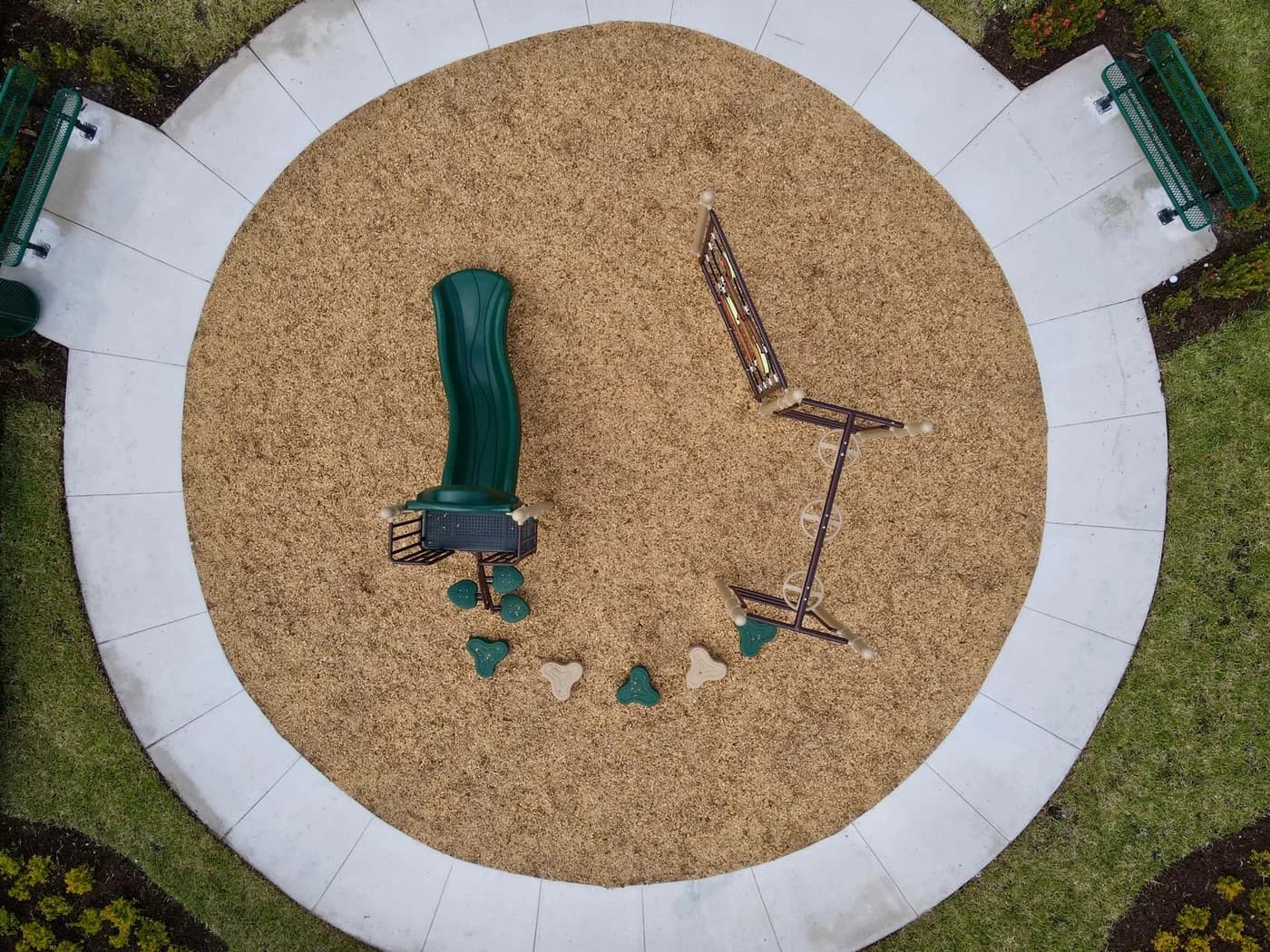 Overhead view showing the slide, climbing structure and stepping pods inside the wood fiber circle