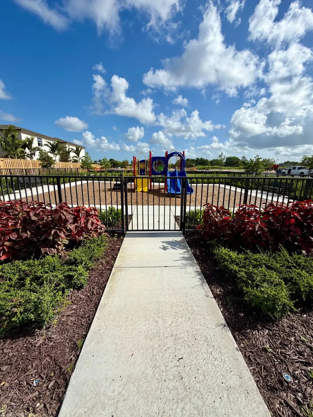 Fenced Coral Landings play area with walkway