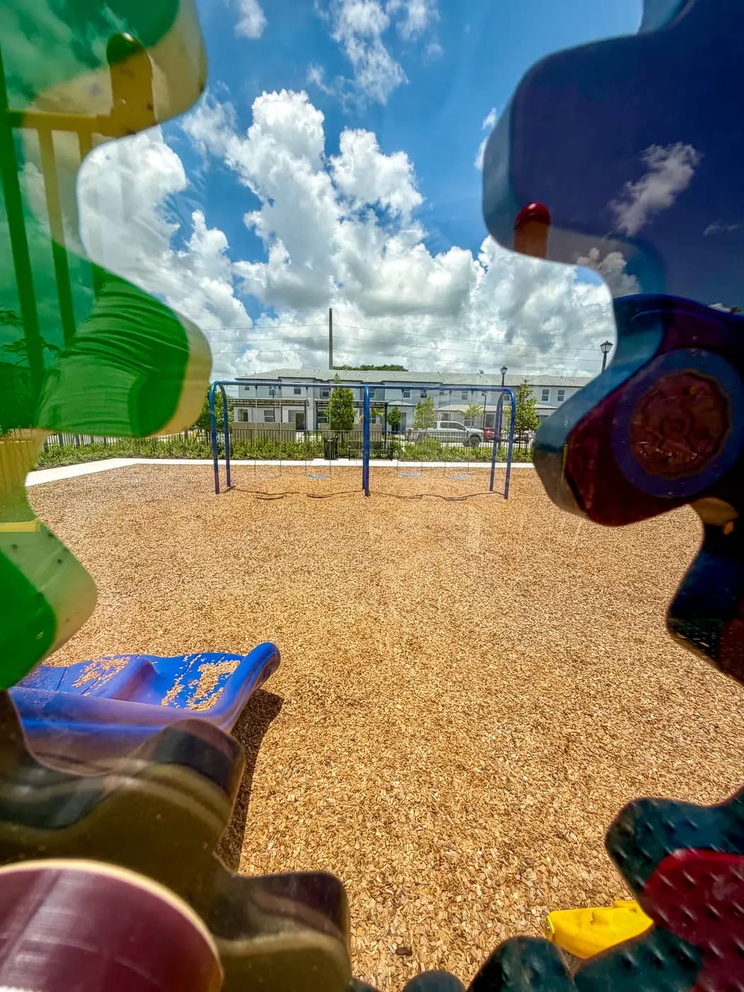 Sensory play panels at ground level beside the main play structure