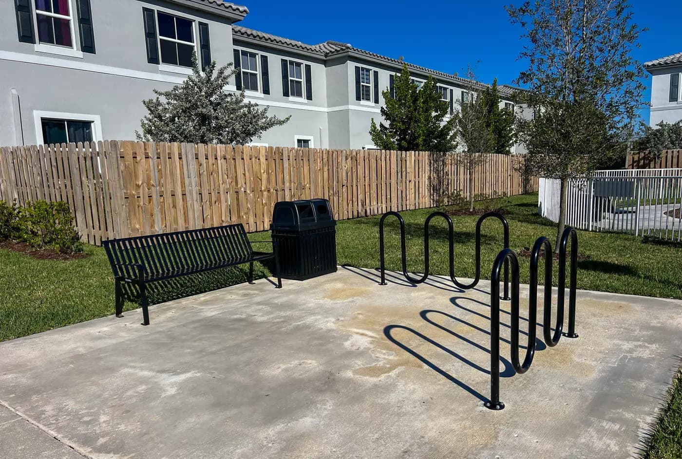 Bench, trash receptacle and bike racks at a community amenity corner