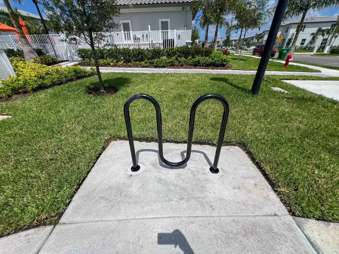 Loop bike rack on a concrete pad near the community pool house