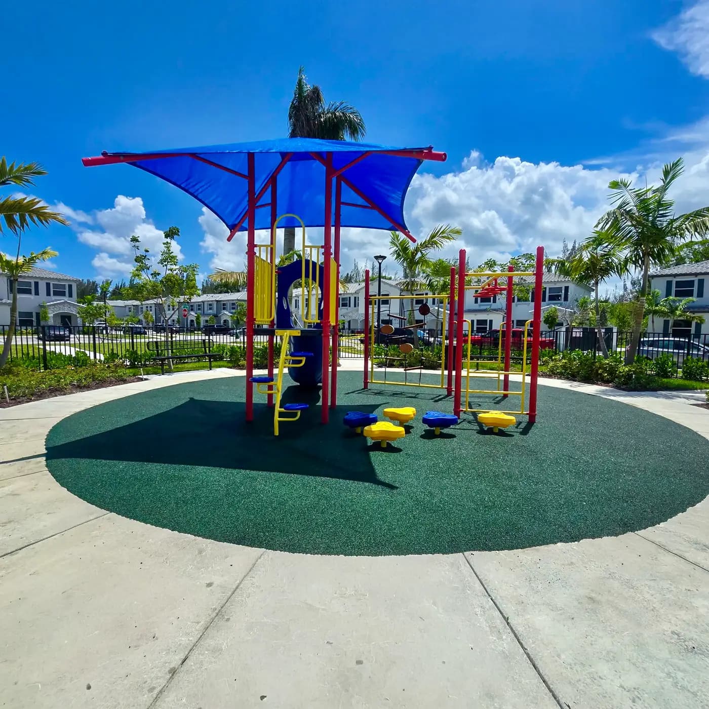 Le Jardine playground with palms and townhomes around it