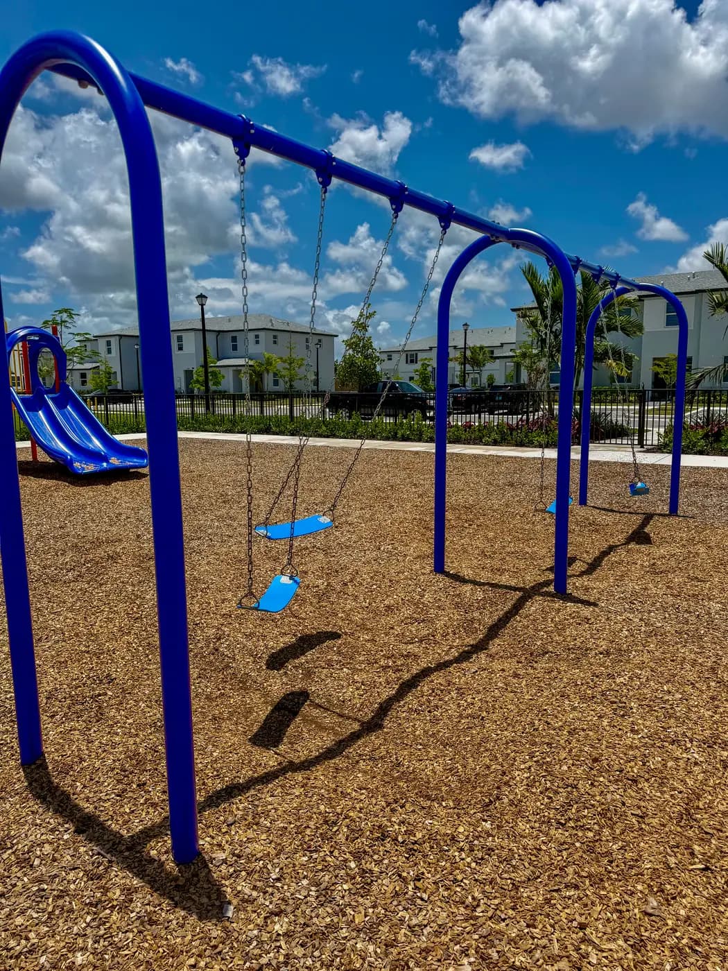 Swing seats and toddler slide at the Vivant Community park